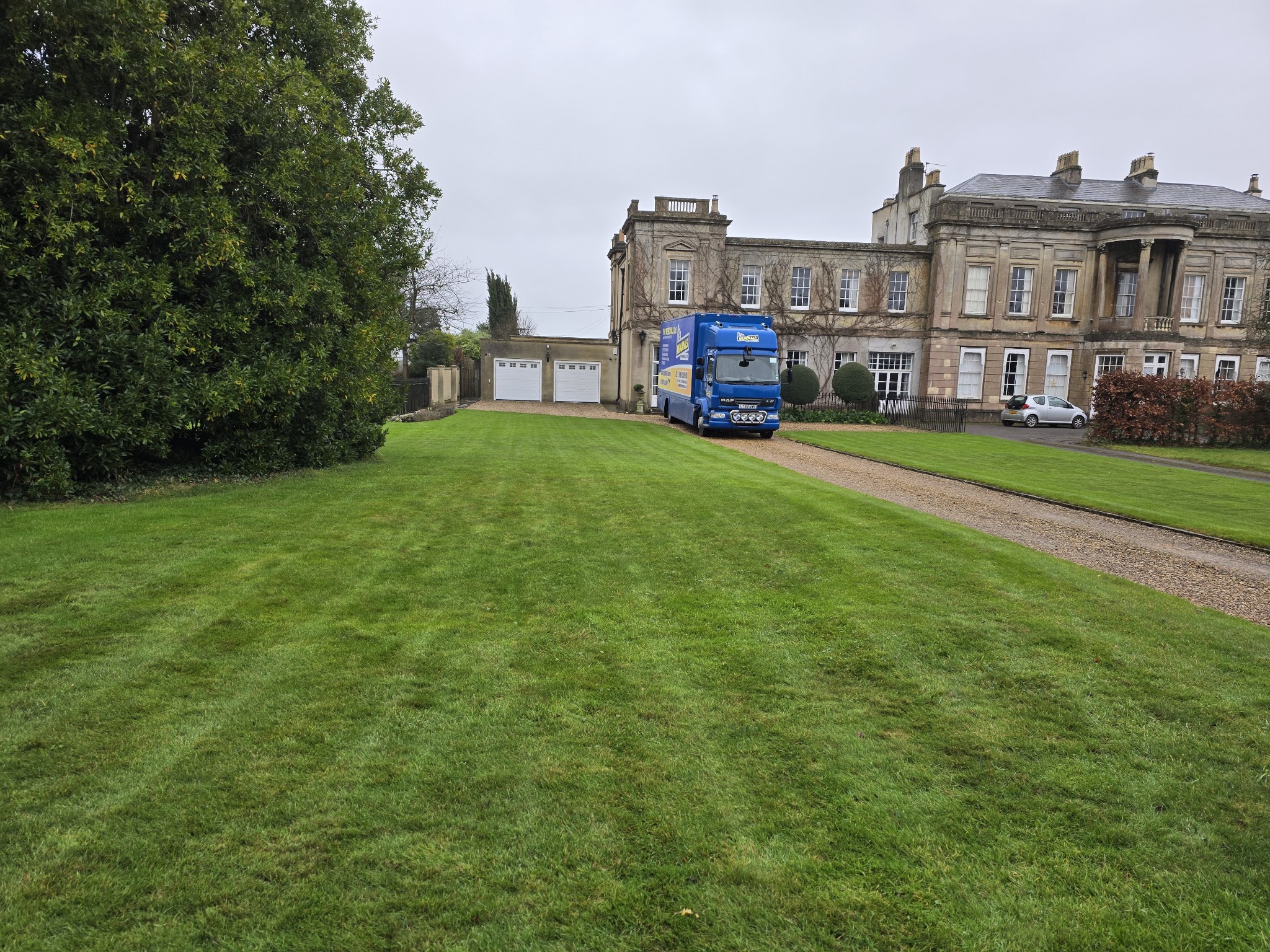 A navy VVP lorry on the long drive of a country house