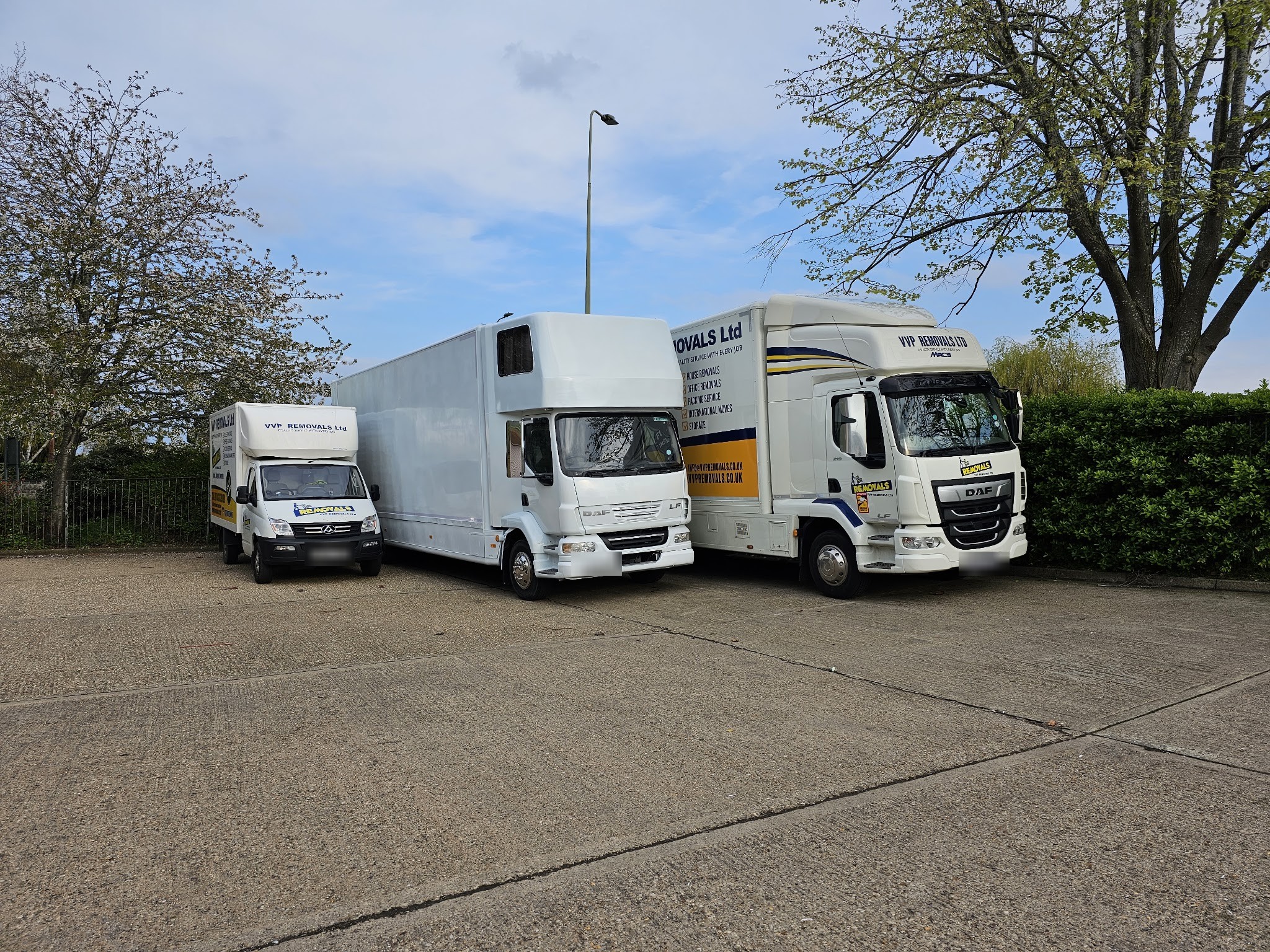 A white VVP van, Luton and lorry parked together on a concrete yard